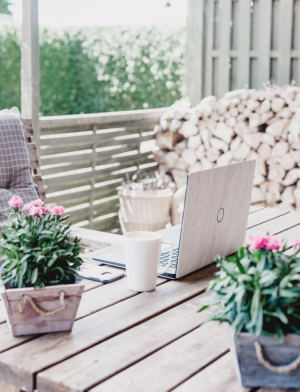 Laptop Outside with Stacked Wood in Background